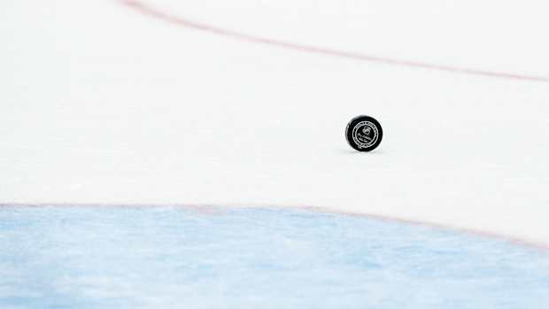 An NHL hockey puck rolling on the ice